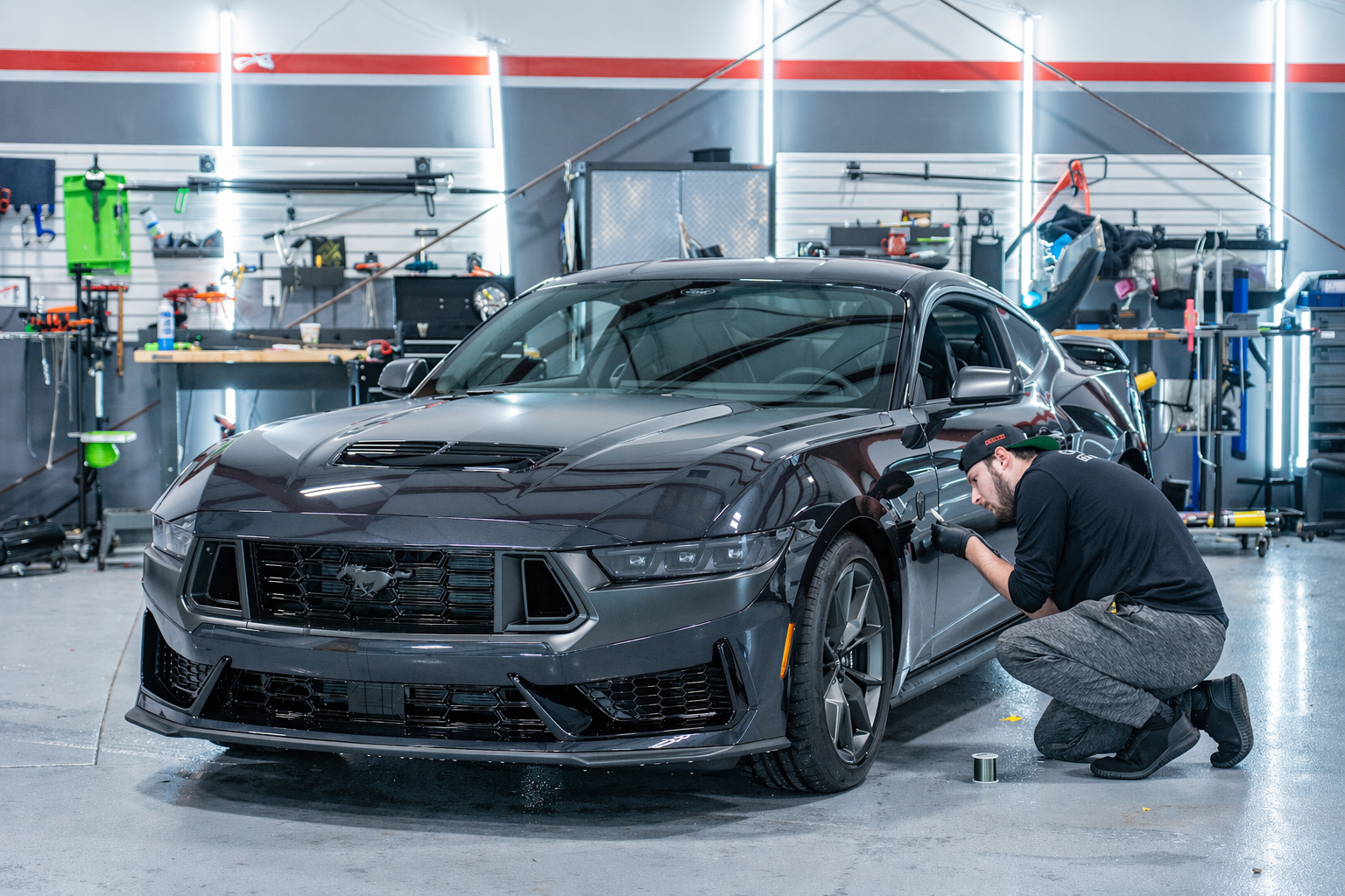 Technician applying paint protection film to a Mustang Dark Horse